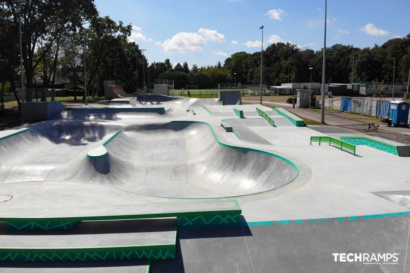 Panoramiczny widok na skatepark w Zielonce z różnorodnymi przeszkodami i przestronnym bowl'e