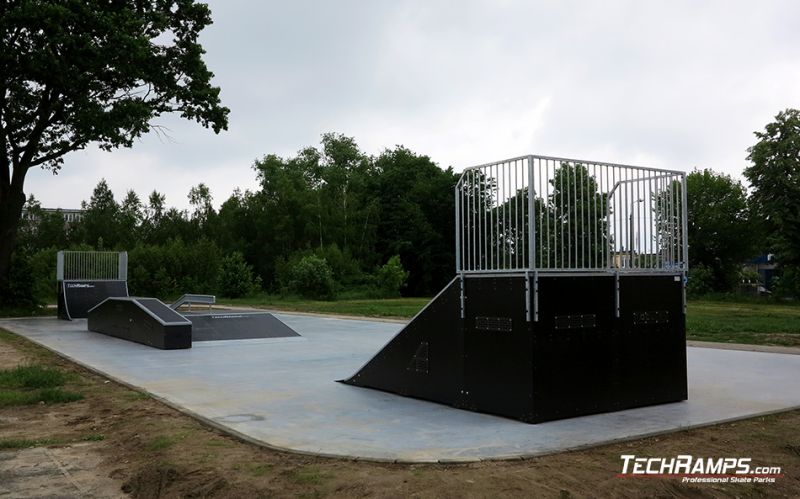 Whole skatepark with black modules and concrete flat