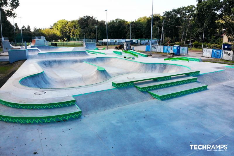 Skatepark w Zielonce z przestronnym bowl'em oraz przeszkodami w sekcji street, otoczony zielenią